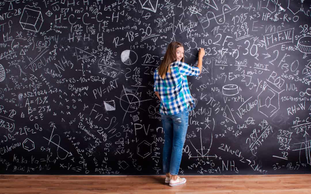 Student writing on big blackboard with mathematical symbols