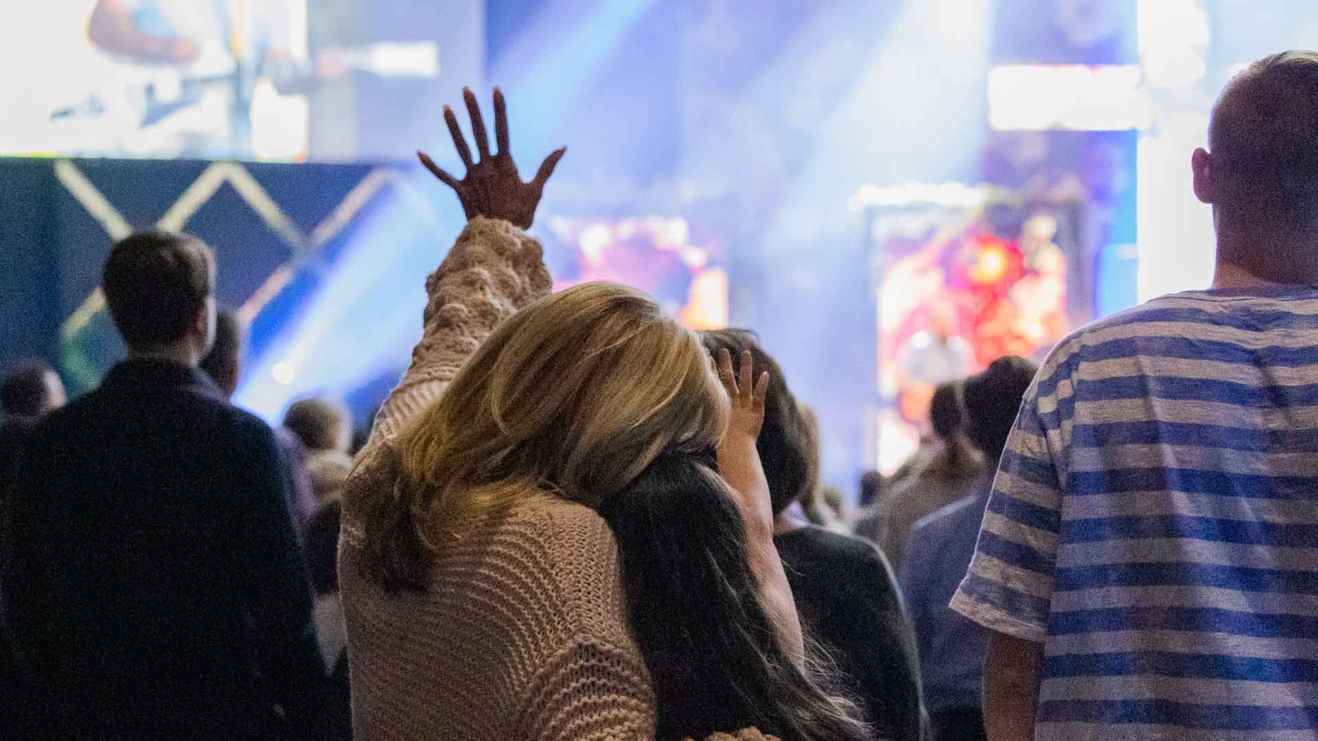 mother and daughter with hands raised worshiping