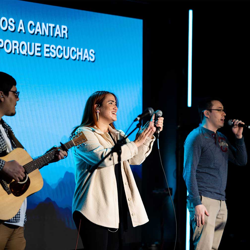 three people singing on stage
